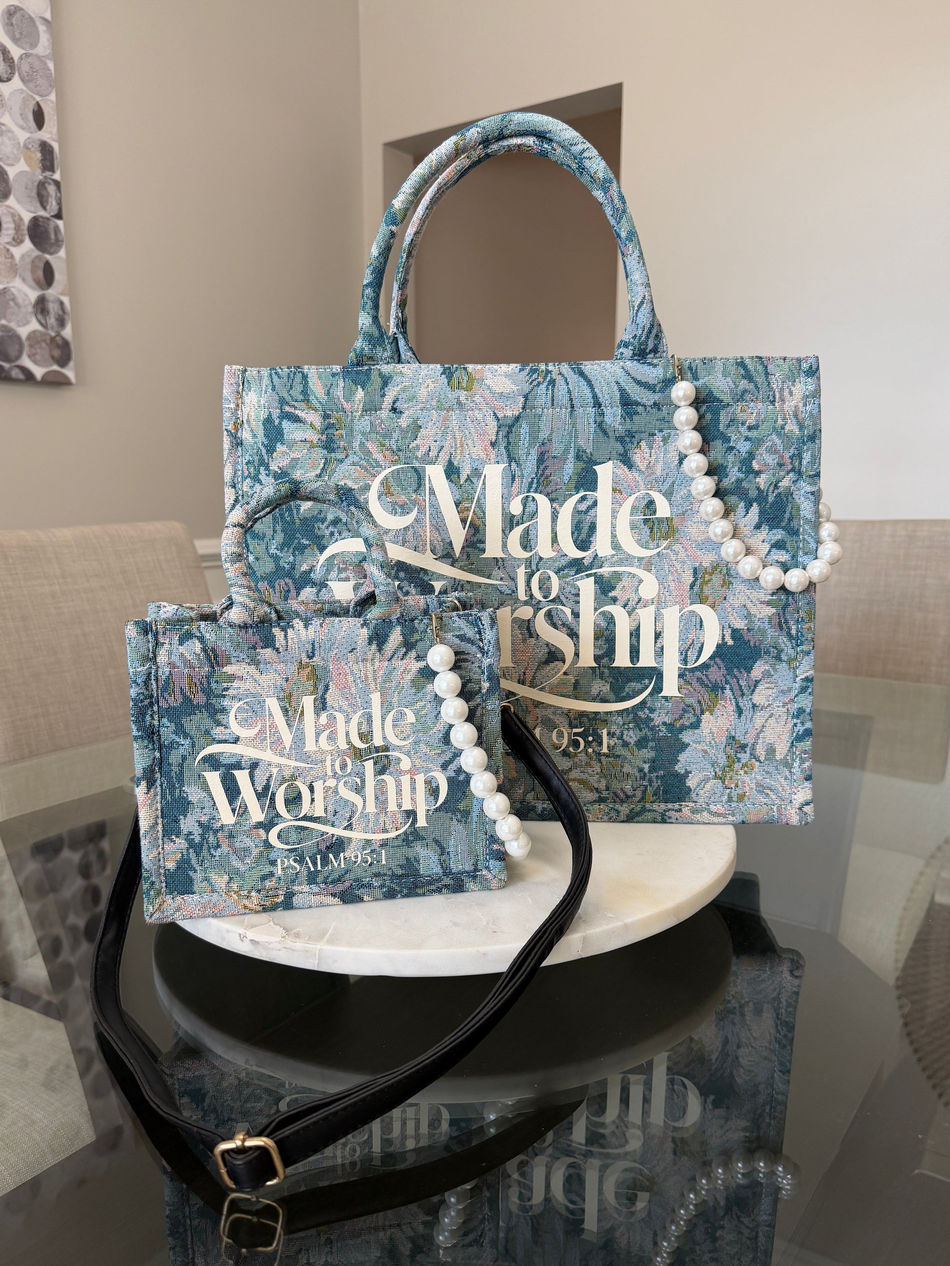 Blue floral-patterned bag with 'Made to Worship' text on a reflective surface.